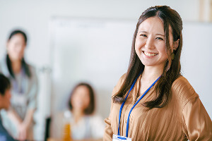 会議室で笑顔で立つ女性リーダー