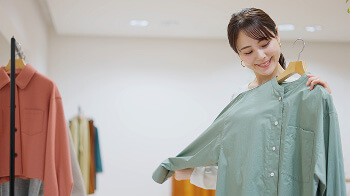 店で服を選び試着する女性