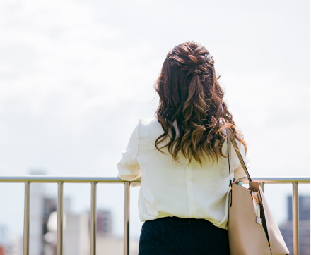 遠くを見つめる女性の後ろ姿